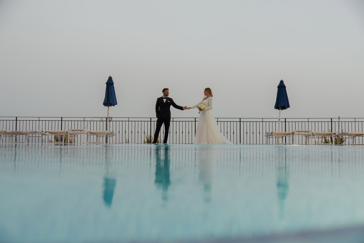 Sposi alla piscina a sfioro vista mare, matrimonio elegante in Costiera Amalfitana
